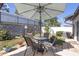 Charming outdoor patio with a dining table and umbrella, set amidst lush greenery and landscaping for relaxing at 36568 Garden Wall Way, Zephyrhills, FL 33541