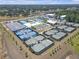 Aerial view of multiple well-maintained tennis courts with blue and green surfaces, in a planned community at 36568 Garden Wall Way, Zephyrhills, FL 33541