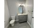 Modern half bathroom with gray vanity, quartz countertop, and gray tile floors at 37533 Teri Ct, Dade City, FL 33525
