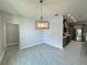 Gray tiled floor dining room with modern light fixture and adjoining modern kitchen at 37533 Teri Ct, Dade City, FL 33525