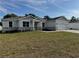 Beautifully crafted exterior featuring stone accents, complemented by lush landscaping, creating a modern aesthetic at 37533 Teri Ct, Dade City, FL 33525