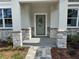Inviting front porch area showcasing stone columns and a decorative front door, enhancing curb appeal at 37533 Teri Ct, Dade City, FL 33525
