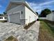 Attached garage with stone detailing and a paved driveway, blending functionality with stylish design at 37533 Teri Ct, Dade City, FL 33525