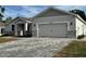Two-car garage with brick paver driveway, stone veneer and neutral color palette at 37533 Teri Ct, Dade City, FL 33525