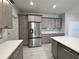 Modern kitchen featuring stainless steel refrigerator and lots of gray cabinets and storage at 37533 Teri Ct, Dade City, FL 33525