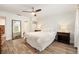 Well-lit bedroom with wood-look tile flooring features two bedside tables and a view to the bathroom at 408 S Arrawana Ave # A4, Tampa, FL 33609