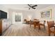 Spacious living room with wood-look tile flooring features a ceiling fan and sliding glass doors to the outside patio at 408 S Arrawana Ave # A4, Tampa, FL 33609