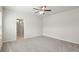 Unfurnished bedroom with gray carpet and ceiling fan, leading to a Primary bathroom at 4086 Polynesia Rd, North Port, FL 34288