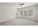 A spacious bedroom with neutral carpet, three windows with blinds, and a ceiling fan at 4086 Polynesia Rd, North Port, FL 34288