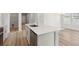 Close-up of the kitchen island with stainless steel dishwasher, faucet, and hardwood flooring at 4086 Polynesia Rd, North Port, FL 34288