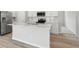 Modern kitchen with a large island, stainless steel appliances, white cabinets, and hardwood floors at 4086 Polynesia Rd, North Port, FL 34288