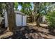 Backyard with a storage shed and screened-in porch amongst mature trees offering shade at 420 S Matanzas Ave, Tampa, FL 33609