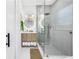 Elegant bathroom featuring a glass shower, stylish vanity with storage, and a circular mirror with lighting at 420 S Matanzas Ave, Tampa, FL 33609