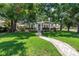 Charming home with manicured lawn and brick path leading to the front door, set among mature trees at 420 S Matanzas Ave, Tampa, FL 33609
