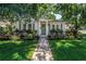 Charming home featuring a quaint walkway, lush landscaping, and inviting curb appeal with a fresh green door at 420 S Matanzas Ave, Tampa, FL 33609