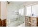 Renovated bathroom features a glass-enclosed tub and shower with a white tile surround and a window at 4901 Venetian Ne Blvd, St Petersburg, FL 33703