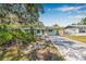Inviting single-story home featuring a well-manicured front yard, covered parking and a cozy porch area at 4901 Venetian Ne Blvd, St Petersburg, FL 33703