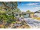Quaint single story home with light blue paint, carport and mature trees at 4901 Venetian Ne Blvd, St Petersburg, FL 33703