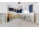 Kitchen area with blue cabinets, a modern light fixture, tile backsplash, and a window for ample natural light at 4901 Venetian Ne Blvd, St Petersburg, FL 33703