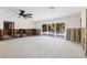 Spacious living room features a ceiling fan, large sliding glass doors to the backyard, and concrete flooring at 4901 Venetian Ne Blvd, St Petersburg, FL 33703