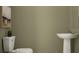 A minimalist bathroom featuring a toilet and sink with sleek fixtures, offering a clean and functional space at 5129 Benjamin Eric St, Zephyrhills, FL 33541