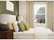Comfortable bedroom with a bed, accent pillows, modern furnishings, and natural light at 5129 Benjamin Eric St, Zephyrhills, FL 33541