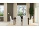 Inviting dining room with a dark wood table, white chairs, and bright natural light at 5129 Benjamin Eric St, Zephyrhills, FL 33541