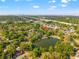 Aerial view of a house near a lake, surrounded by trees, with downtown visible at 5804 N 9Th St, Tampa, FL 33604