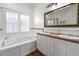 Bright bathroom with soaking tub, dual sinks, and large mirror at 5804 N 9Th St, Tampa, FL 33604