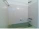 Bathtub with green tile and shower fixture at 6251 Danbury St, Spring Hill, FL 34606