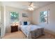 Bright bedroom with two windows, ceiling fan, side table, and a neatly made bed at 6251 Danbury St, Spring Hill, FL 34606