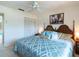 Cozy bedroom featuring white walls, a ceiling fan, closet and a bed with patterned comforter at 6251 Danbury St, Spring Hill, FL 34606