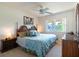 Bright bedroom with a large window, ceiling fan, and a bed with blue patterned comforter at 6251 Danbury St, Spring Hill, FL 34606