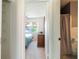 Hallway view leading to the main bedroom and a bathroom, with a glimpse of the bedroom and natural light at 6251 Danbury St, Spring Hill, FL 34606