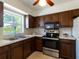 Cozy kitchen with dark wood cabinets, stainless steel appliances and bright natural light at 6251 Danbury St, Spring Hill, FL 34606
