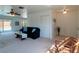 Bright living room featuring neutral carpet, a ceiling fan, and sliding glass doors leading to the pool area at 6251 Danbury St, Spring Hill, FL 34606