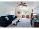 Open-concept living room with carpet, ceiling fan and ample natural light streaming through a large window at 6251 Danbury St, Spring Hill, FL 34606
