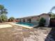 Backyard pool with a beige deck, surrounded by palm trees and view of the home's rear at 6251 Danbury St, Spring Hill, FL 34606
