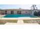 Backyard pool with a beige deck, surrounded by palm trees and view of the home's rear at 6251 Danbury St, Spring Hill, FL 34606
