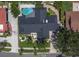 An aerial view of a modern home highlighting its dark roof, pool, and meticulously landscaped yard at 7108 Pelican Island Dr, Tampa, FL 33634