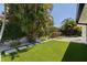 Spacious backyard featuring lush artificial turf, mature trees, and stylish pavers, perfect for outdoor activities at 7108 Pelican Island Dr, Tampa, FL 33634