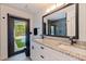 Modern bathroom with double sinks, granite countertops, black fixtures, and a view of the pool at 7108 Pelican Island Dr, Tampa, FL 33634