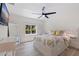Bright bedroom featuring a leafy bedspread, modern ceiling fan, and natural light from the window at 7108 Pelican Island Dr, Tampa, FL 33634