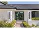 Elegant home entrance with modern lighting fixtures and a neatly manicured walkway leading to double doors at 7108 Pelican Island Dr, Tampa, FL 33634