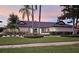Stunning single-story home featuring a well-manicured lawn, lush landscaping, and a dark tile roof at 7108 Pelican Island Dr, Tampa, FL 33634