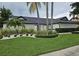 Stunning single-story home with lush green lawn, palm trees, and elegant landscaping at 7108 Pelican Island Dr, Tampa, FL 33634
