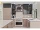 Bright kitchen featuring stainless steel appliances, a modern range hood, and light-colored cabinets at 7108 Pelican Island Dr, Tampa, FL 33634