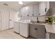 Well-equipped laundry room with washer, dryer, utility sink, ample cabinet storage, and granite countertops at 7108 Pelican Island Dr, Tampa, FL 33634