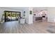 Open-concept living space showcasing sleek flooring, a stone fireplace, and seamless access to the outdoor pool area at 7108 Pelican Island Dr, Tampa, FL 33634