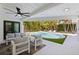 Inviting covered patio featuring sleek furniture and a view of the refreshing pool and lush landscaping at 7108 Pelican Island Dr, Tampa, FL 33634